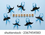 Small photo of Movember concept - event to raise awareness of men's health issues, moustache anf blue ribbon