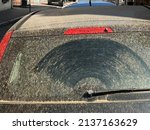 Car in Colmar, France covered with windblown Sahara sand and dust. Rear view of car with even layer of orange colored fine dust.