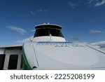 Small photo of Friedrichshafen, Germany 09 03 2022: Wheelhouse with dark view screen of cruise tourist catamaran painted white and green sailing in Lake Constance. View from forecastle deck on navigational bridge.