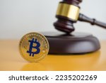 Bitcoin and hammer judge gavel on yellow table with white wall background copy space. Bitcoin cryptocurrency is regulated by government. Regulation and law for cryptocurrency concept.