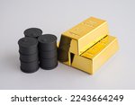 Small photo of Black crude oil tanks vs gold bars on white background copy space. Commodity trading, investment, risk management, invest trategy plan, relationship between gold and oil price concept.