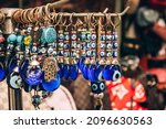 Small photo of Traditional evil eye bead - protection amulet at souvenir store. Popular touristic souvenir and talisman in different countries around the world. Symbol of protection against malevolent gazes