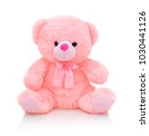 Small photo of Cute pink bear doll with bow isolated on white background with shadow reflection. Playful bright pink bear sitting on white underlay. Teddy bear plush stuffed puppet with ribbon on white backdrop.