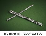 Small photo of Black and white striped straw tubule on a green background. Paper drinking straw isolated on green background.