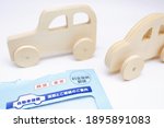Small photo of Car insurance documents and car toys. Translations: Parenthetical, Important, Postage Due, Auto Insurance, Maturity and Renewal Information.