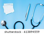 stethoscope on a blue table ... | Shutterstock . vector #613894559