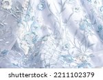 blue festive fabric decorated with embroidery and sequins for wedding dress. glossy textile for sewing prom dress