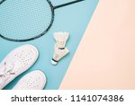 Shuttlecock and badminton racket with sport shoes on pastel color background