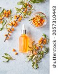 Small photo of Glass bottle with sea buckthorn oil, berries and branches of sea buckthorn on light background. Self-care, cosmetics, beauty practices, self-care concept.