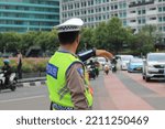Small photo of The police are controlling vehicle traffic, which is starting to get heavy in downtown Jakarta at noon. traffic police.