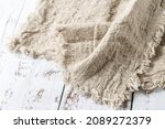 Crumpled natural linen kitchen serviette towel on vintage wooden table. Rustic background with copy space