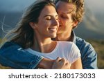 Small photo of Close-up of loving caucasian young man cuddling and romancing with happy beautiful girlfriend during outing at sunset