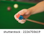 Hand's of snooker is chalking cue. Concept of playing activity, entertainment leisure, billiards, snooker or pool ball. Blue chalk. Hobbies and lifestyles.