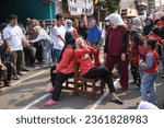 Small photo of Tangerang, Indonesia - August 17 2023 : Hijab woman is having competition for seats or "Rebut Kursi" to commemorate indonesia's independence day