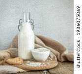 Small photo of Vegan rice milk and bowl with a rice .Non dairy , alternative milk. Healthy vegetarian food and drink concept. Copy space . A bottle of rice milk and raw rice on a wooden table and a napkin .