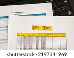 Small photo of Close up shot of a print outs of excel table of a bank loan amortization table, personal balance sheet and laptop