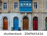 Small photo of Traditional colorful Maltese doors in Valletta.Front doors to houses from Malta.Blue red brown doors and wooden balcony.Maltese vintage apartment building.Popular travel destination.Entrance to house