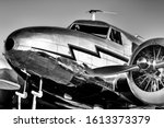 Low, front-quarter view of a gleaming, silver, vintage, lockheed electra from the golden age of aviation.