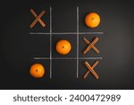 Small photo of Game of Tic-tac-toe with cinnamon and tangerine on a black background