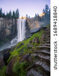 Waterfalls full of mist at Vernal Fall Yosemite. Mist hiking trail with rock carved foot steps leading to the beauty of the waterfalls.