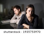 Angry couple ignoring each other sitting in the living room at home in the night
