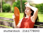 Small photo of Woman in a park suffering heat stroke fanning