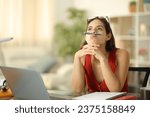 Small photo of Bored student with laptop wasting time sitting at home