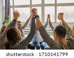 young caucasian people celebrating recovery from alcohol addiction, team work of anonymous addicts club, raised hands up together