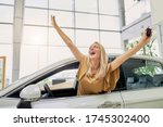Small photo of beautiful happy female got keys by her new automobile, dreams come true. attractive lady sit inside of car and squeals with happiness
