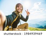 Young woman taking selfie portrait hiking mountains - Happy hiker on the top of the cliff smiling at camera - Travel and hobby concept
