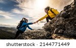 Small photo of People helping each other hike up a mountain at sunrise - Giving helping hand and teamwork concept