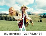 Happy couple enjoying summertime in grass field - Tourists on vacation visiting italian dolomites alps - Two lovers having day trip in the nature 