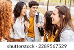 Small photo of University students talking and laughing together in college campus - Happy teenagers having fun going to school - Friendship concept with guys and girls hanging out on summer day