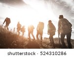 Group of hikers walking on a mountain at sunset