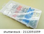 Small photo of A set of colored crimp terminals for electrical wires. Crimping sleeves of different sizes. Plastic spare parts box for electrician. Toolbox. Selective focus