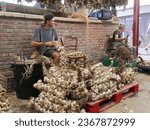 Small photo of Arleux, France - 09 02 2023 : Foire a l'Ail Fume (Smoked Garlic Fair), in Arleux, direct sales of smoked garlic braids in various sizes, garlic soup tasting...