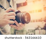 Photography or traveler Concept.The photographer hold DSRL camera in his hands with cityscape blur background and sunlight in summer time, selective focus. Photo of Vintage and filtered process.