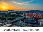 Beautiful aerial photo of Bratislava city and castle above Danube river at sunset in summer from drone. Beautiful shot of capital of Slovakia with St. Martin's Cathedral, Kamzik TV tower and old town.