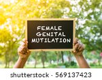 Small photo of FEMALE GENITAL MUTILATION write on black board with hand hold the board