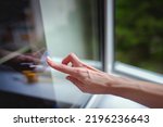 Small photo of A woman's hand sticks decals on windows for birds. These decals has a special coating that reflects ultraviolet sunlight, which help prevent wild birds from accidentally striking windows.