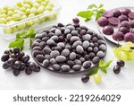 Small photo of Methods for freezing grapes: bulk frozen, frozen with sugar and frozen puree on a light gray background. Healthy homemade preparations