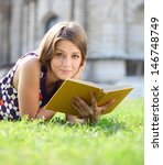 Young Beautiful Girl Reading A...