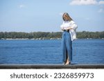 Full body portrait of a young beautiful blonde girl in long blue jeans skirt