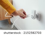 Woman Plugging A Device Into A...