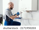 Gas engineer writing a gas safety certificate and boiler records after servicing