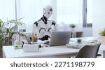 Small photo of A robot resembling a human sits at a desk in an office, using a laptop to showcase the value of automation in repetitive and menial tasks.