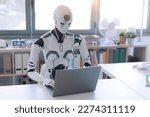 Small photo of A humanoid robot works in an office on a laptop, showcasing the utility of automation in repetitive and tedious tasks.