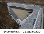 Small photo of triangle-shaped drainage pond with stone wall paneling and gabion walls. the water slows down during the rain and then overflows from the sewer pipe into the sewer. newly completed waterworks