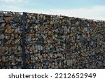 Small photo of construction of a gabion retaining wall, as part of the fencing home coarser gravel filled poured between two wire slabs. stones peek between the meshes of the net