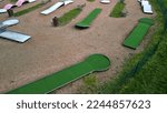 Small photo of minigolf course in park catch golf balls behind obstacle. game for points below par or above par, retirement house, senior, pay, game, tourist, beach, sand, resort, hotel, apartment, circle